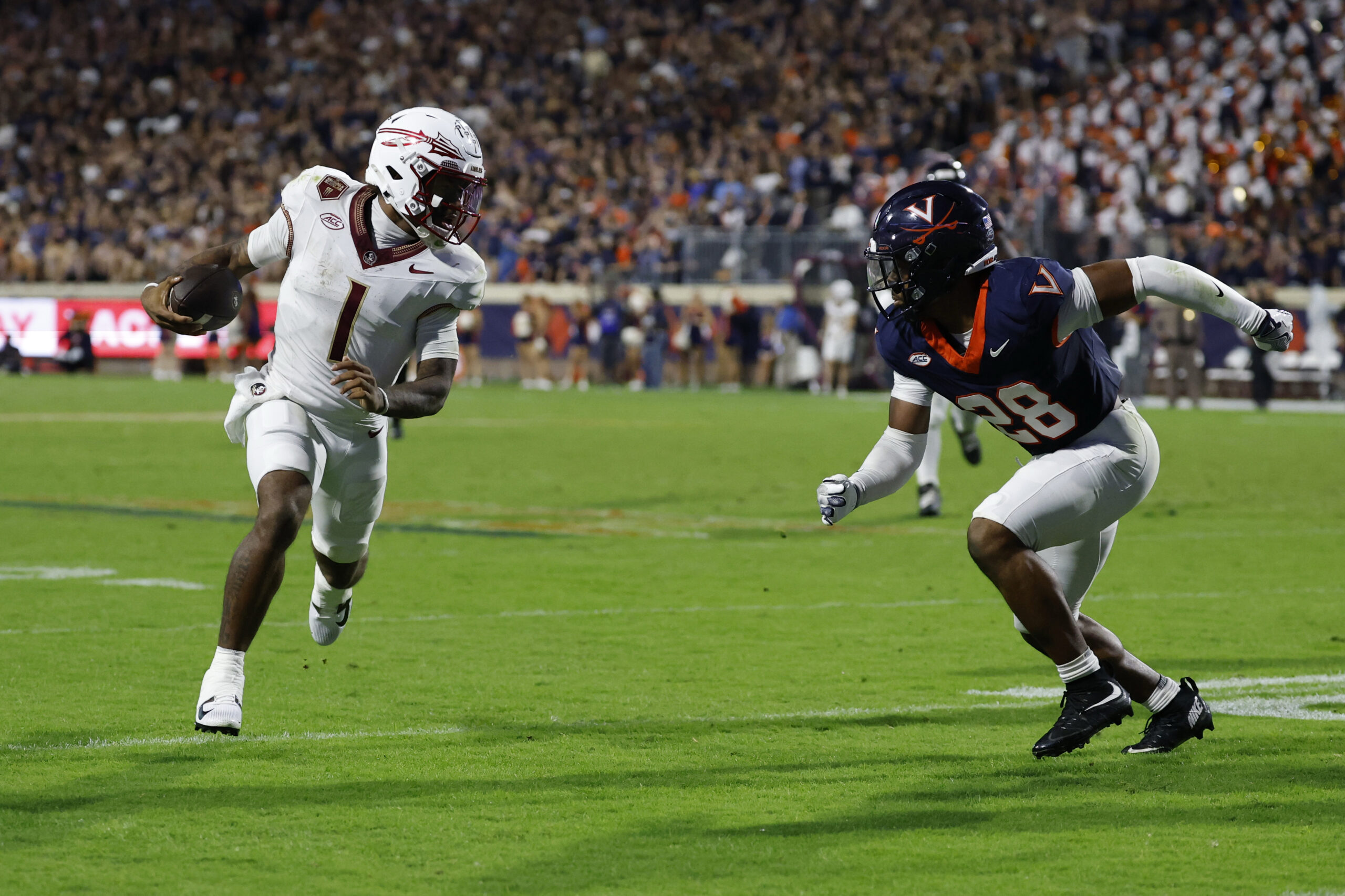 Sep 26, 2025; Charlottesville, Virginia, USA; Florida State Seminoles quarterback Tommy Castellanos (1) runs with the ball as Virginia Cavaliers defensive back Donavon Platt (28) chases at Scott Stadium. Mandatory Credit: Geoff Burke-Imagn Images