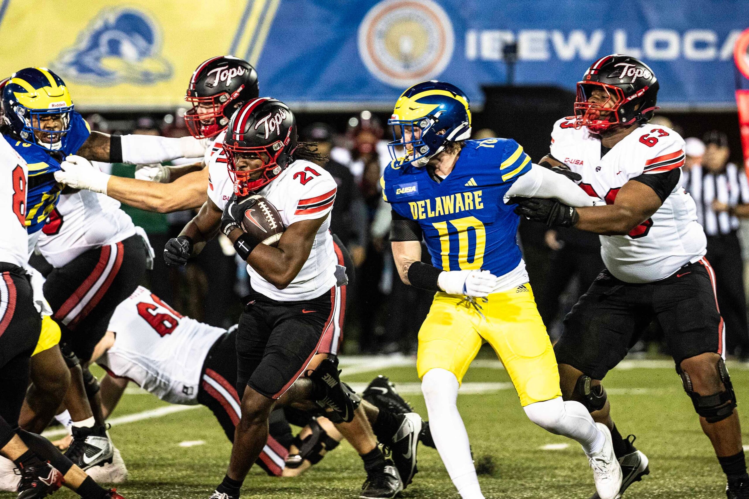 Western Kentucky running back Marvis Parrish (21) runs the ball, with offensive lineman Quincy Jenkins (63) providing cover, against Delaware Blue Hens linebacker Blake Matthews (10) during Delaware's first home CUSA football game, which was nationally televised, at Delaware Stadium in Newark on Oct. 3, 2025. Western Kentucky won 27-24.
