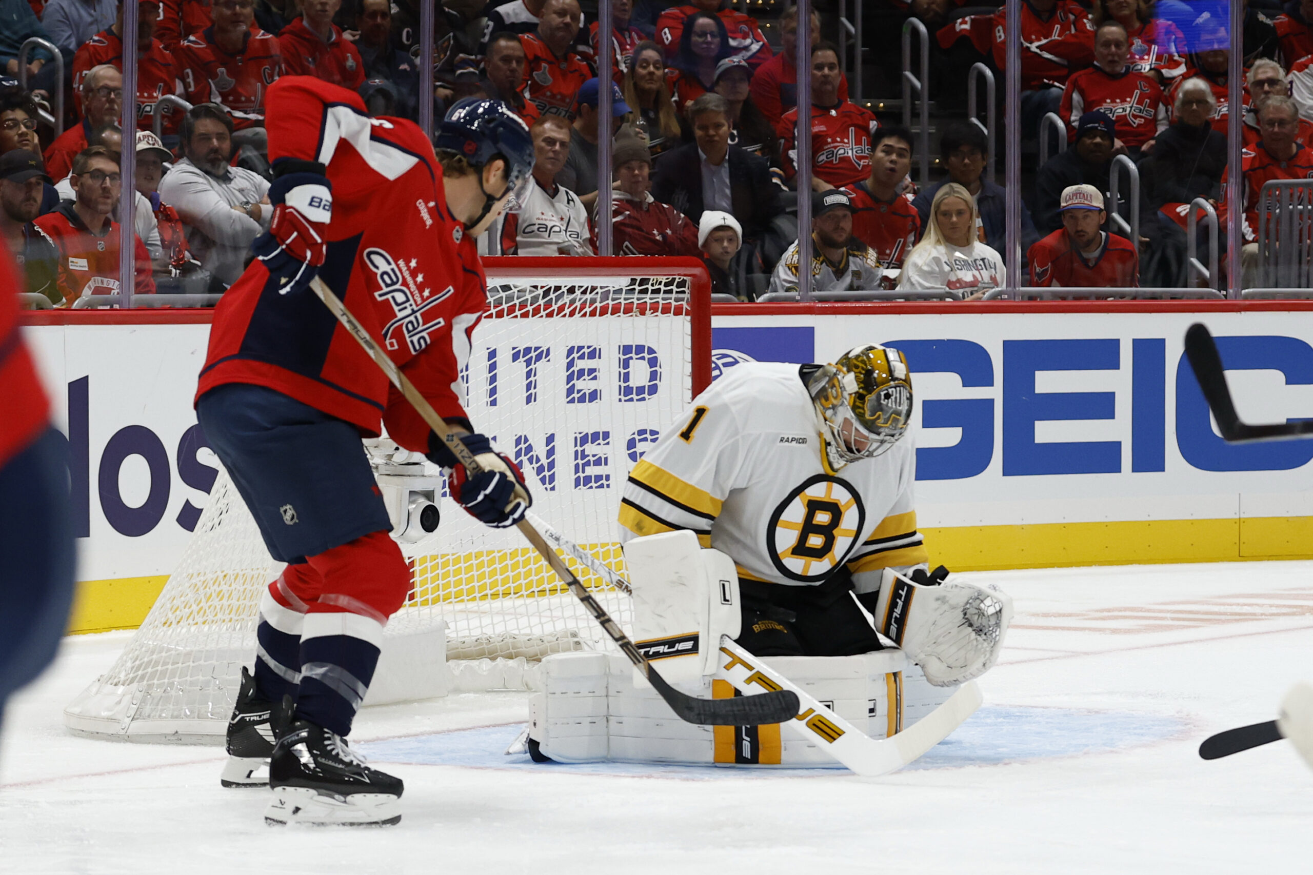 Oct 8, 2025; Washington, District of Columbia, USA; Boston Bruins goaltender Jeremy Swayman (1) makes a save against in front of Washington Capitals defenseman Jakob Chychrun (6) during the first period at Capital One Arena. Mandatory Credit: Geoff Burke-Imagn Images