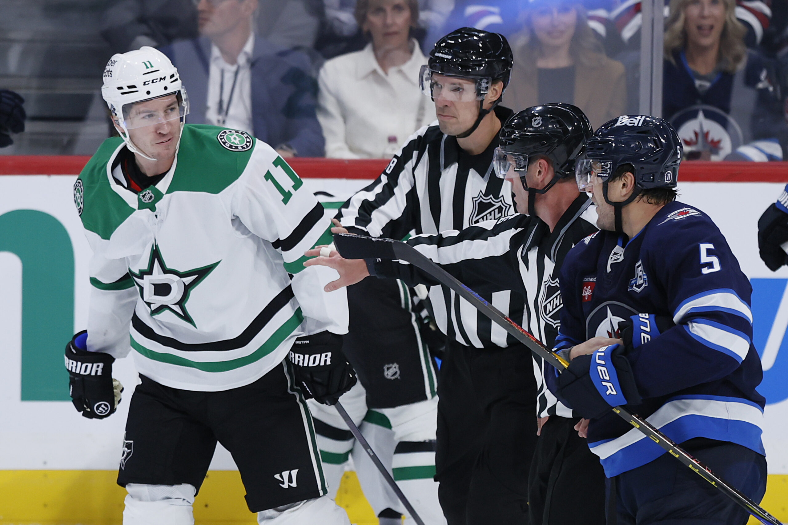 Oct 9, 2025; Winnipeg, Manitoba, CAN; Dallas Stars right wing Nathan Bastian (11) and Winnipeg Jets defenseman Luke Schenn (5) are separated during an altercation in the third period at Canada Life Centre. Mandatory Credit: James Carey Lauder-Imagn Images
