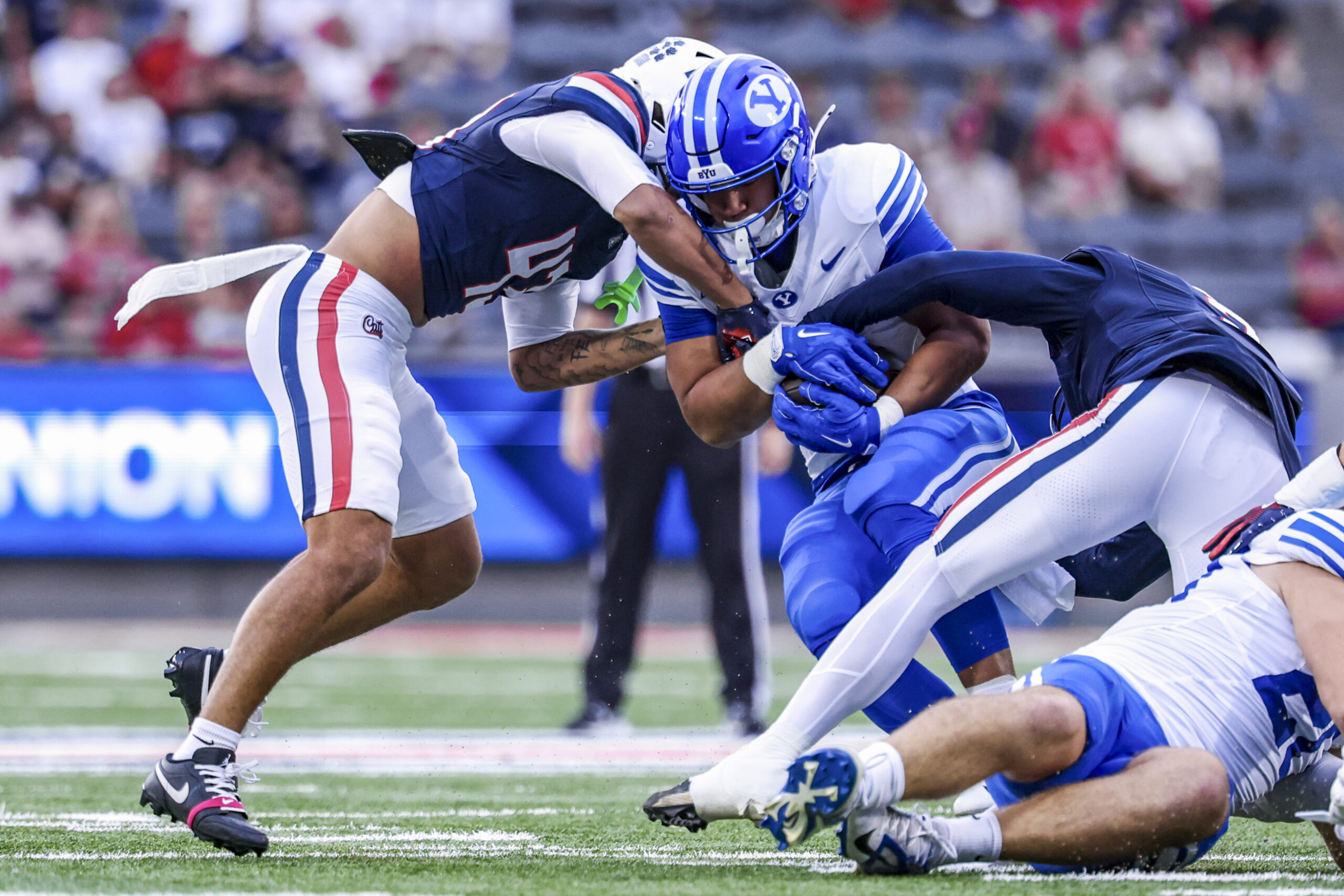 Oct 11, 2025; Tucson, Arizona, USA; Brigham Young Cougars running back LJ Martin (4) gets tackled by Arizona Wildcats defensive back Dalton Johnson (43) during the first quarter of the game at Arizona Stadium. Mandatory Credit: Aryanna Frank-Imagn Images