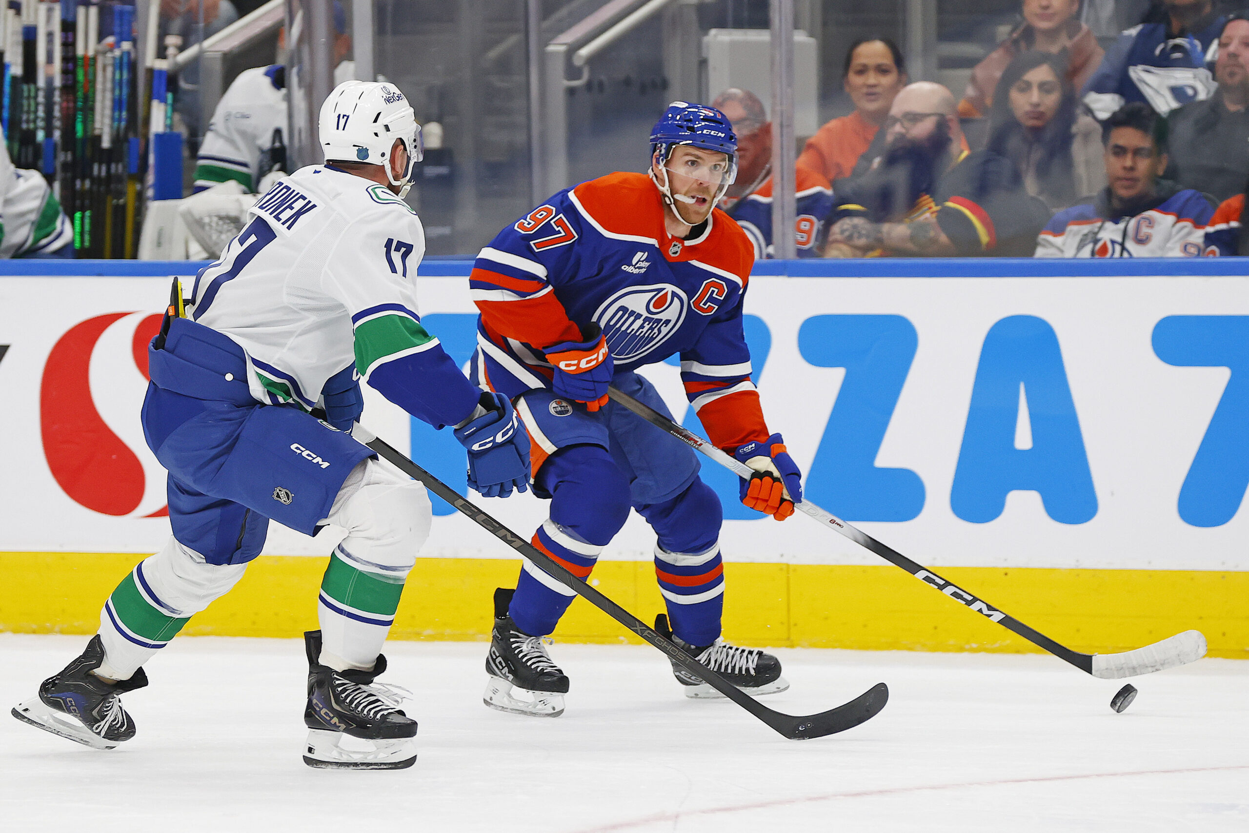 Oct 11, 2025; Edmonton, Alberta, CAN; Edmonton Oilers forward Connor McDavid (97) looks to make a pass in front of Vancouver Canucks defensemen Filip Hornek (17) during the third period at Rogers Place. Mandatory Credit: Perry Nelson-Imagn Images