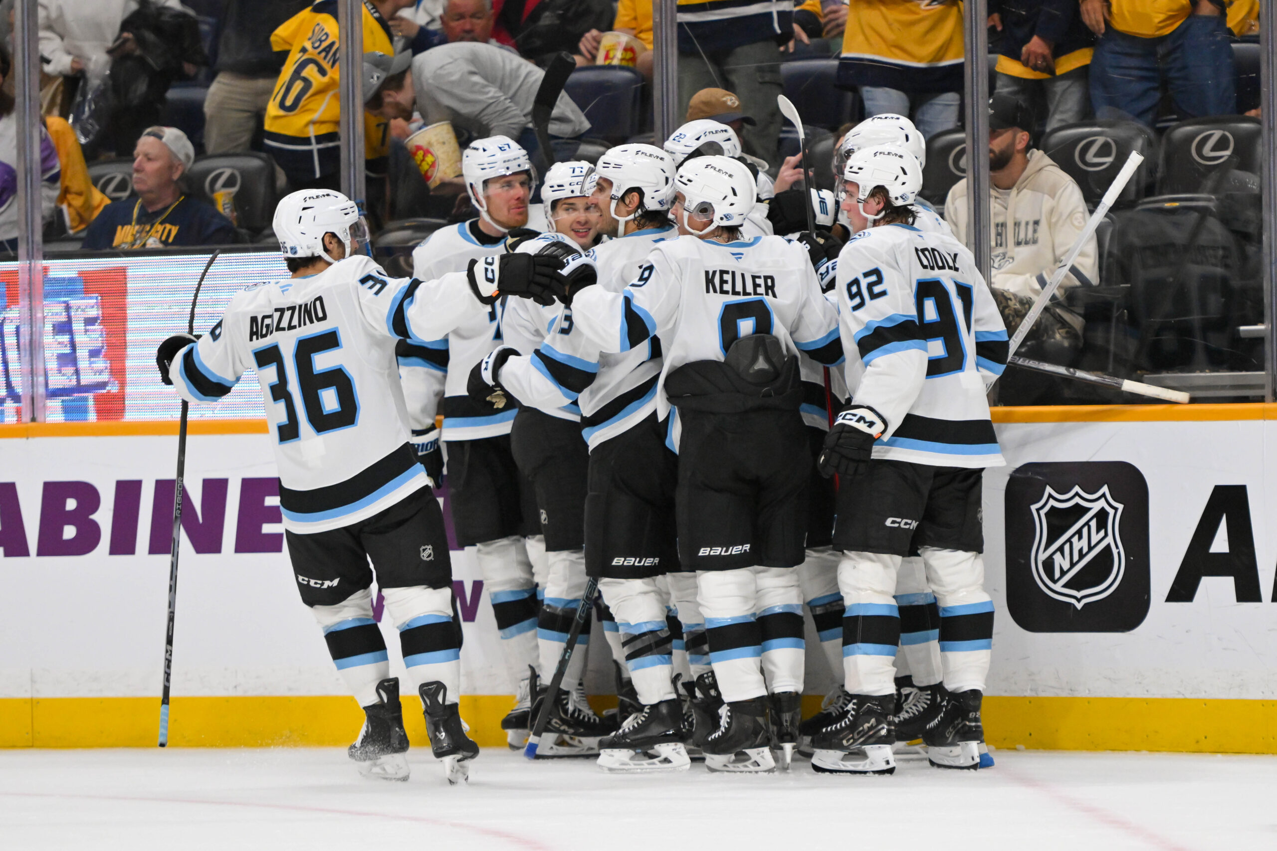 Oct 11, 2025; Nashville, Tennessee, USA;  Utah Mammoth right wing Dylan Guenther (11) celebrates with his teammates after scoring a goal after the game winning goal against the Nashville Predators during the overtime period at Bridgestone Arena. Mandatory Credit: Steve Roberts-Imagn Images
