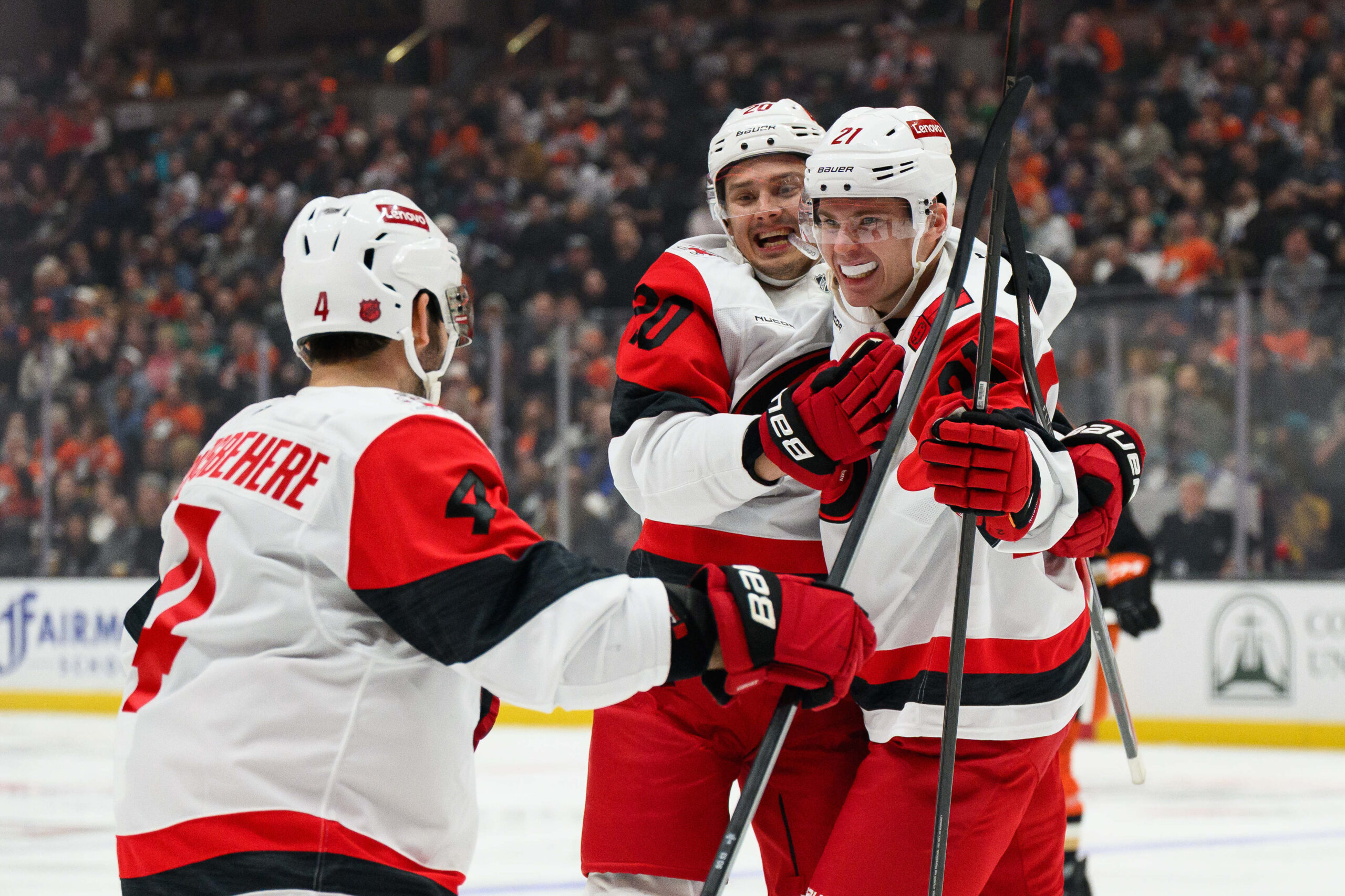 Oct 16, 2025; Anaheim, California, USA; Carolina Hurricanes defenseman Alexander Nikishin (21), right, celebrates with teammates after scoring his first NHL goal during the third period against the Anaheim Ducks at Honda Center. Mandatory Credit: William Liang-Imagn Images