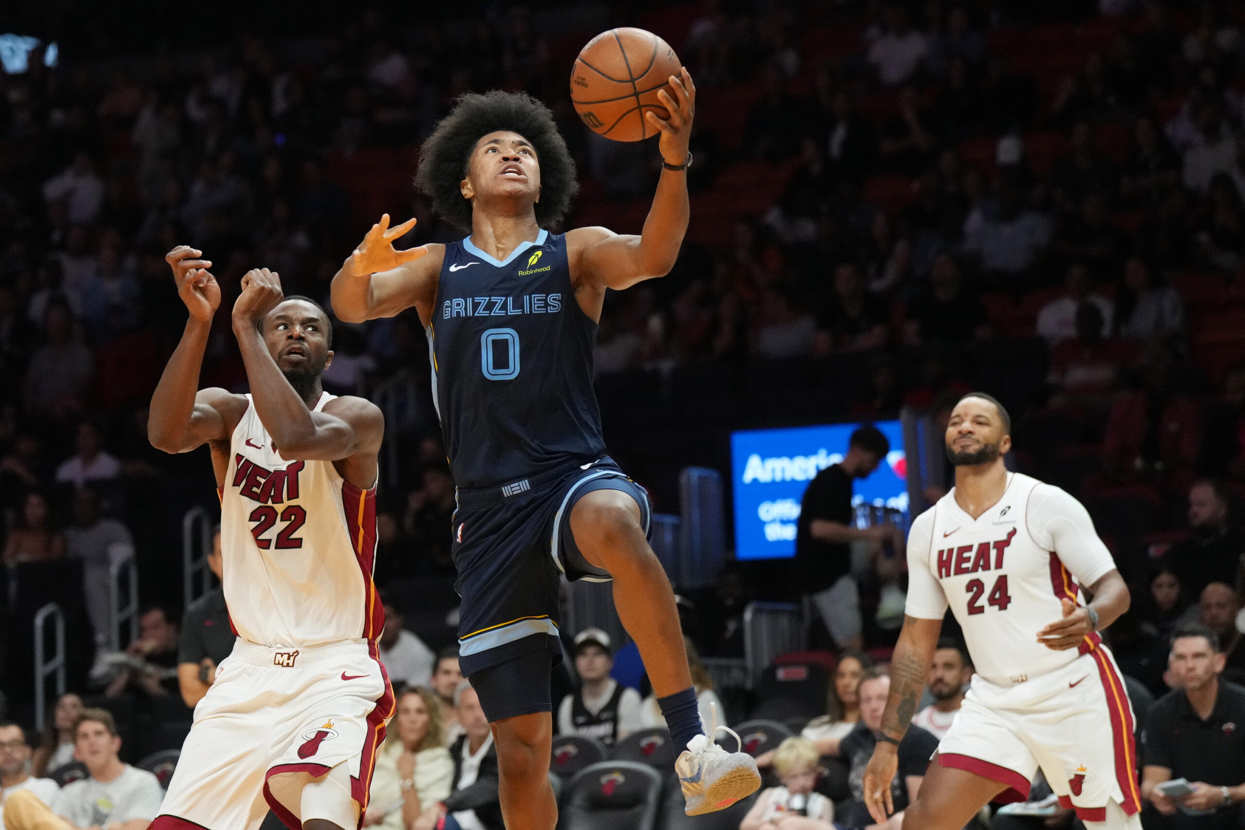 Oct 17, 2025; Miami, Florida, USA;  Memphis Grizzlies guard Jaylen Wells (0) drives to the basket as Miami Heat forward Andrew Wiggins (22) and guard Norman Powell (24) look on during the second half at Kaseya Center. Mandatory Credit: Jim Rassol-Imagn Images