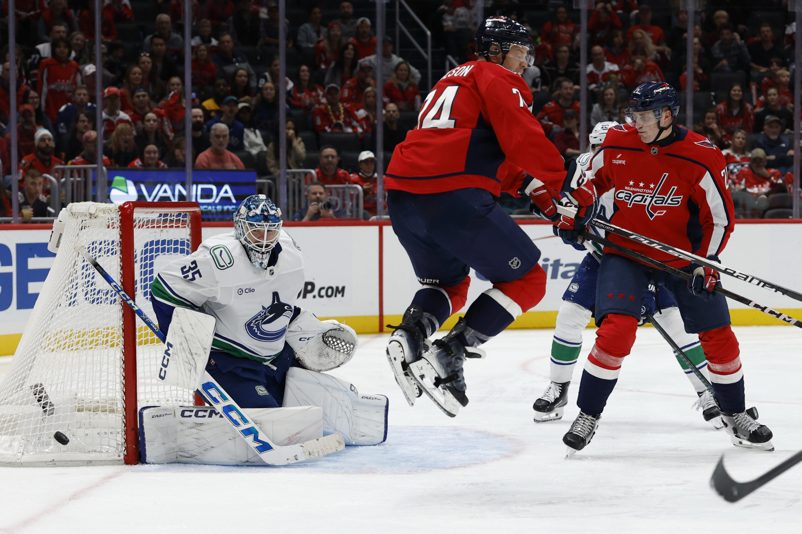 Oct 19, 2025; Washington, District of Columbia, USA; Vancouver Canucks goaltender Thatcher Demko (35) makes a save in front of Washington Capitals defenseman John Carlson (74) and Capitals center Aliaksei Protas (21) during the third period at Capital One Arena. Mandatory Credit: Geoff Burke-Imagn Images