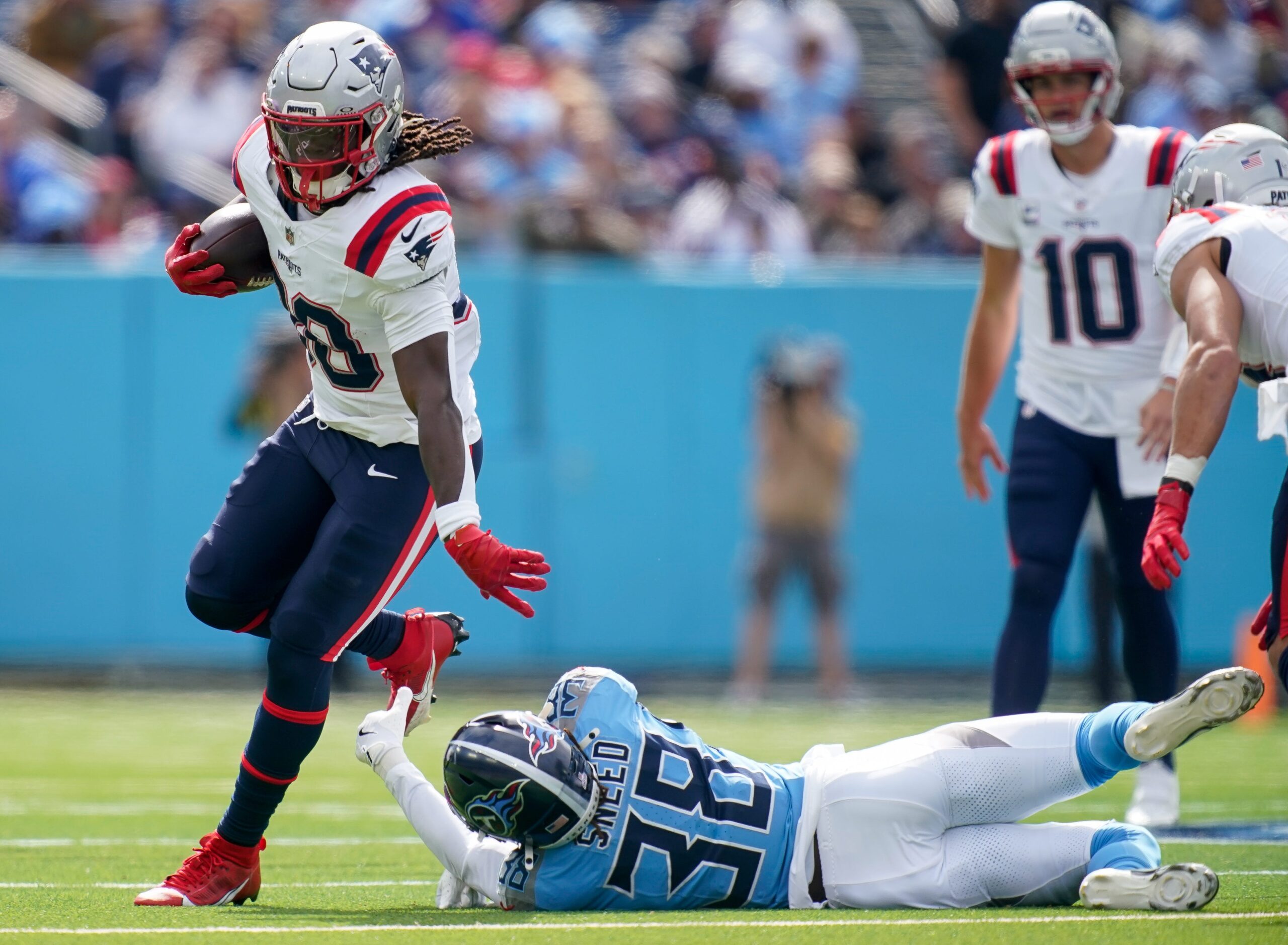 New England Patriots running back Rhamondre Stevenson (38) gets past Tennessee Titans cornerback L'Jarius Sneed (38) during the first quarter at Nissan Stadium in Nashville, Tenn., Sunday, Oct. 19, 2025.
