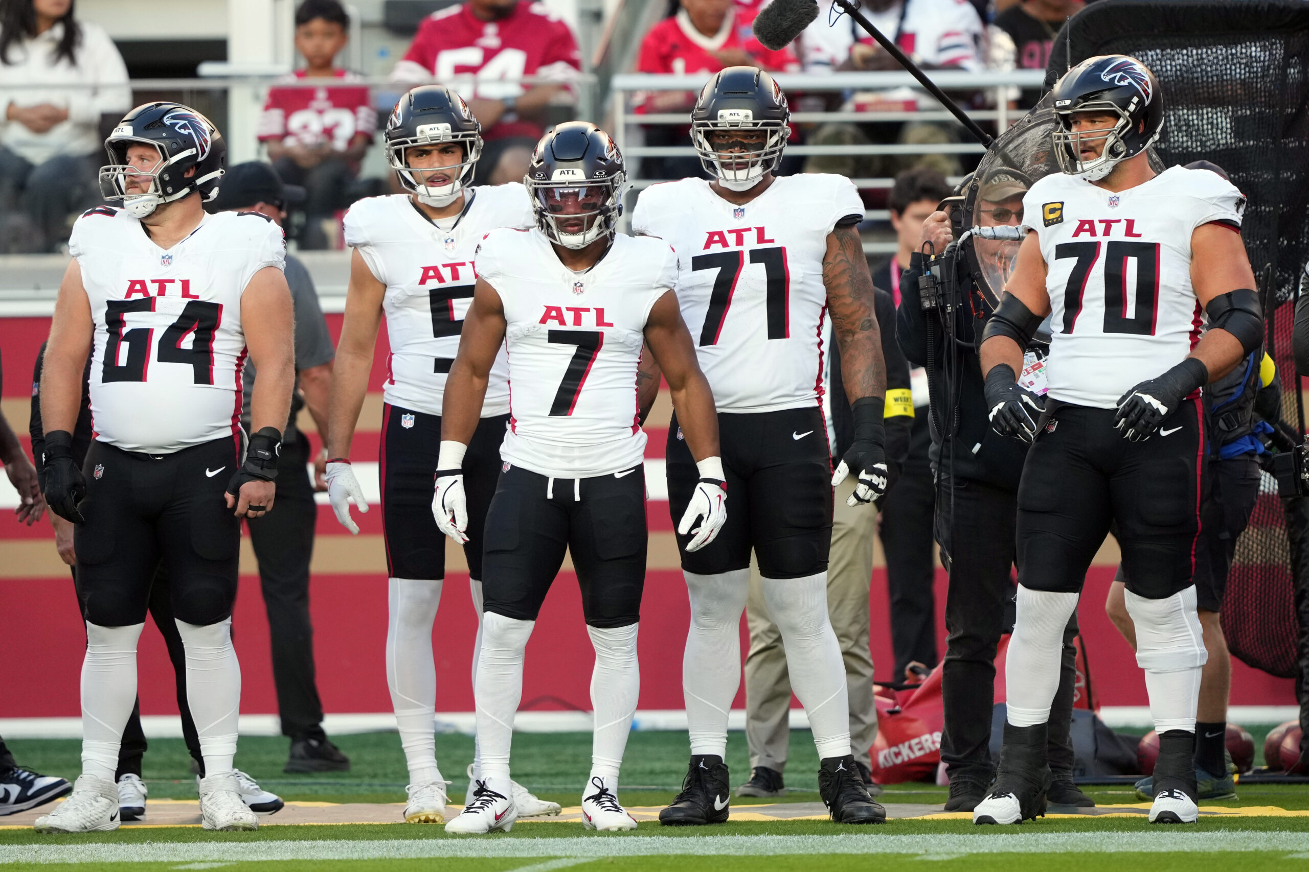 Oct 19, 2025; Santa Clara, California, USA; Atlanta Falcons running back Bijan Robinson (7) stands on the sideline with wide receiver Drake London (center left) and center Ryan Neuzil (64) and offensive tackles Elijah Wilkinson (71) and Jake Matthews (70) before the game against the San Francisco 49ers at Levi's Stadium. Mandatory Credit: Darren Yamashita-Imagn Images