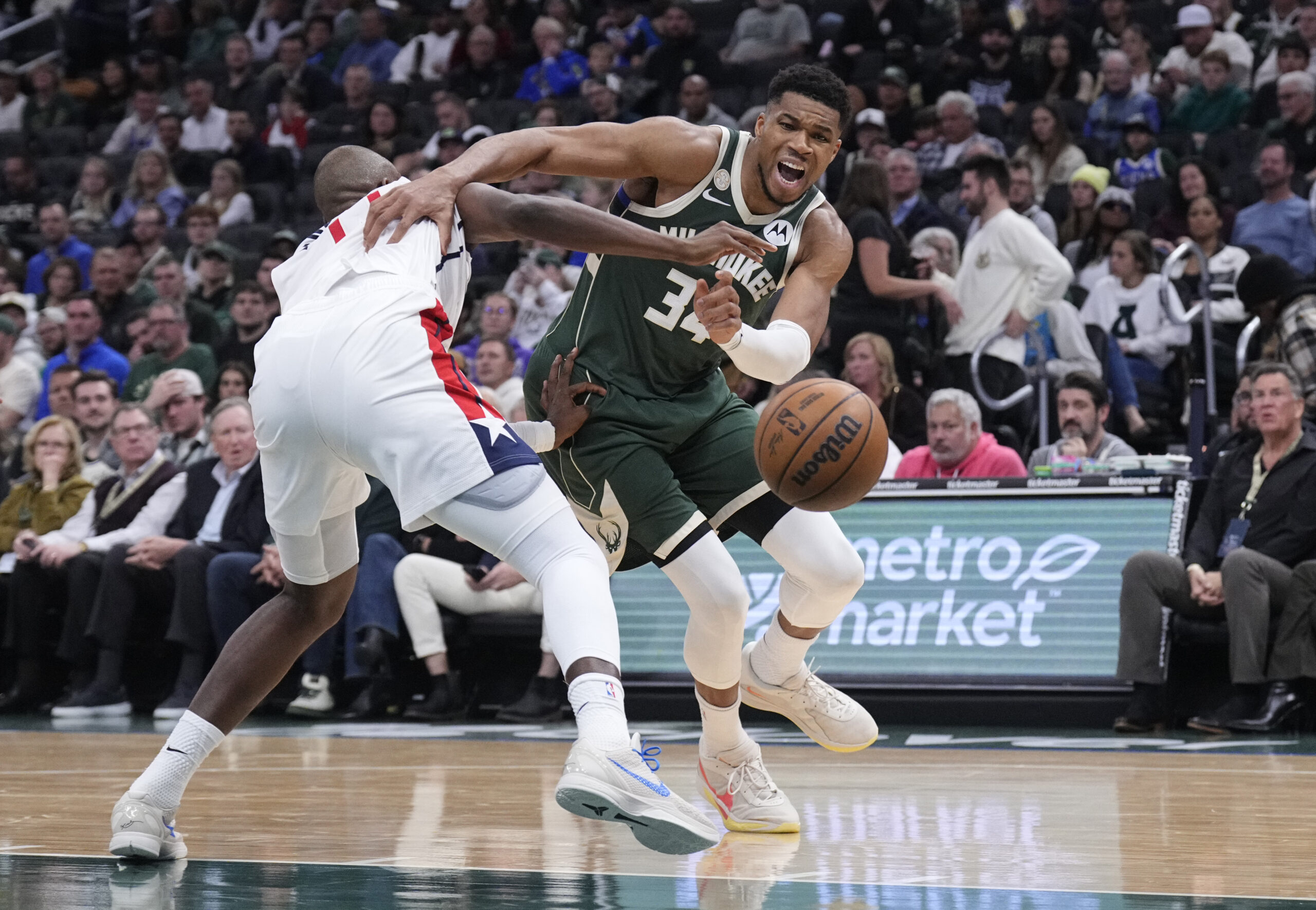 Oct 22, 2025; Milwaukee, Wisconsin, USA; Milwaukee Bucks forward Giannis Antetokounmpo (34) drives against Washington Wizards forward Khris Middleton (22) in the first half at Fiserv Forum. Mandatory Credit: Michael McLoone-Imagn Images