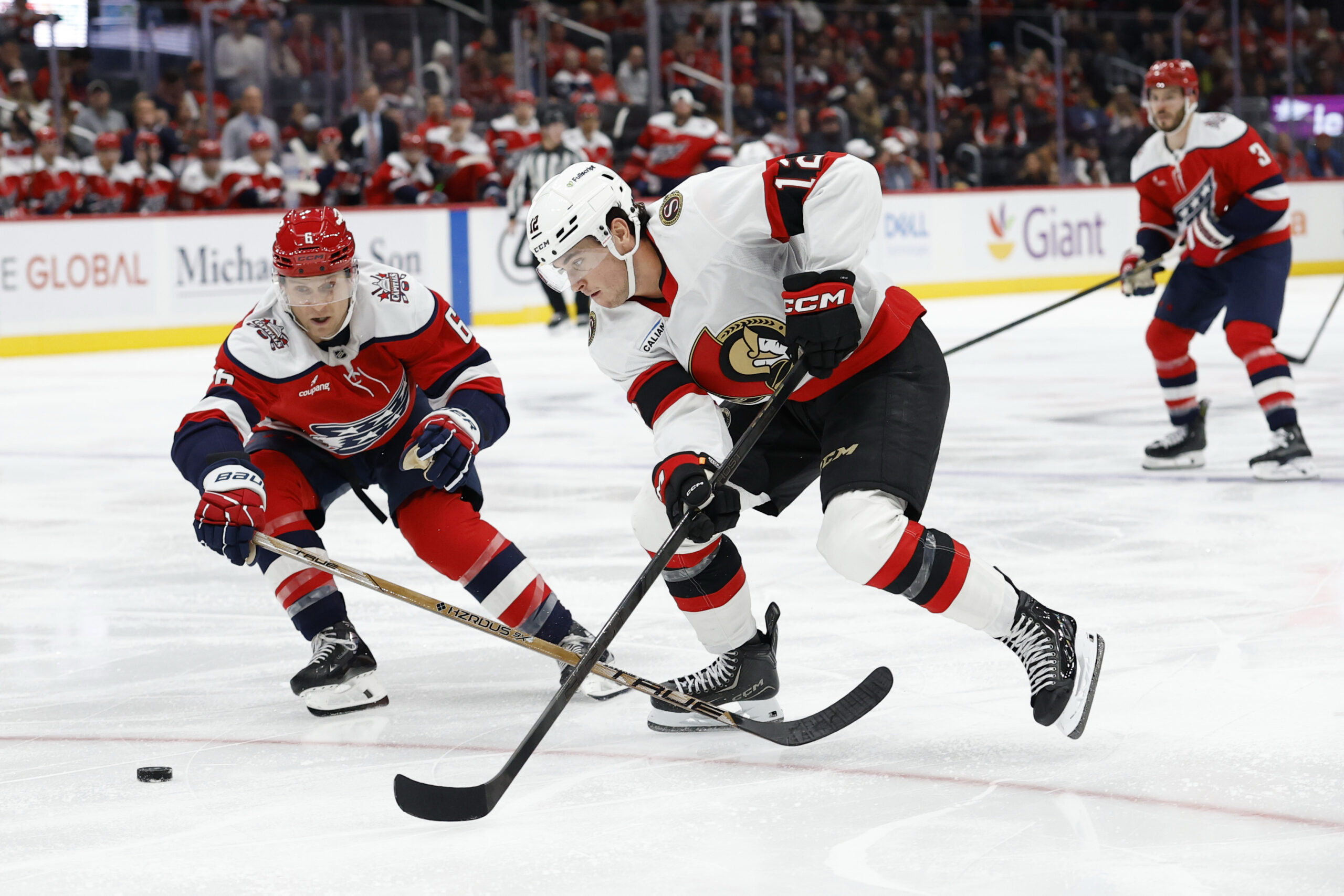 Oct 25, 2025; Washington, District of Columbia, USA; Ottawa Senators center Shane Pinto (12) skates with the puck against as Washington Capitals defenseman Jakob Chychrun (6) chases during the second period at Capital One Arena. Mandatory Credit: Geoff Burke-Imagn Images