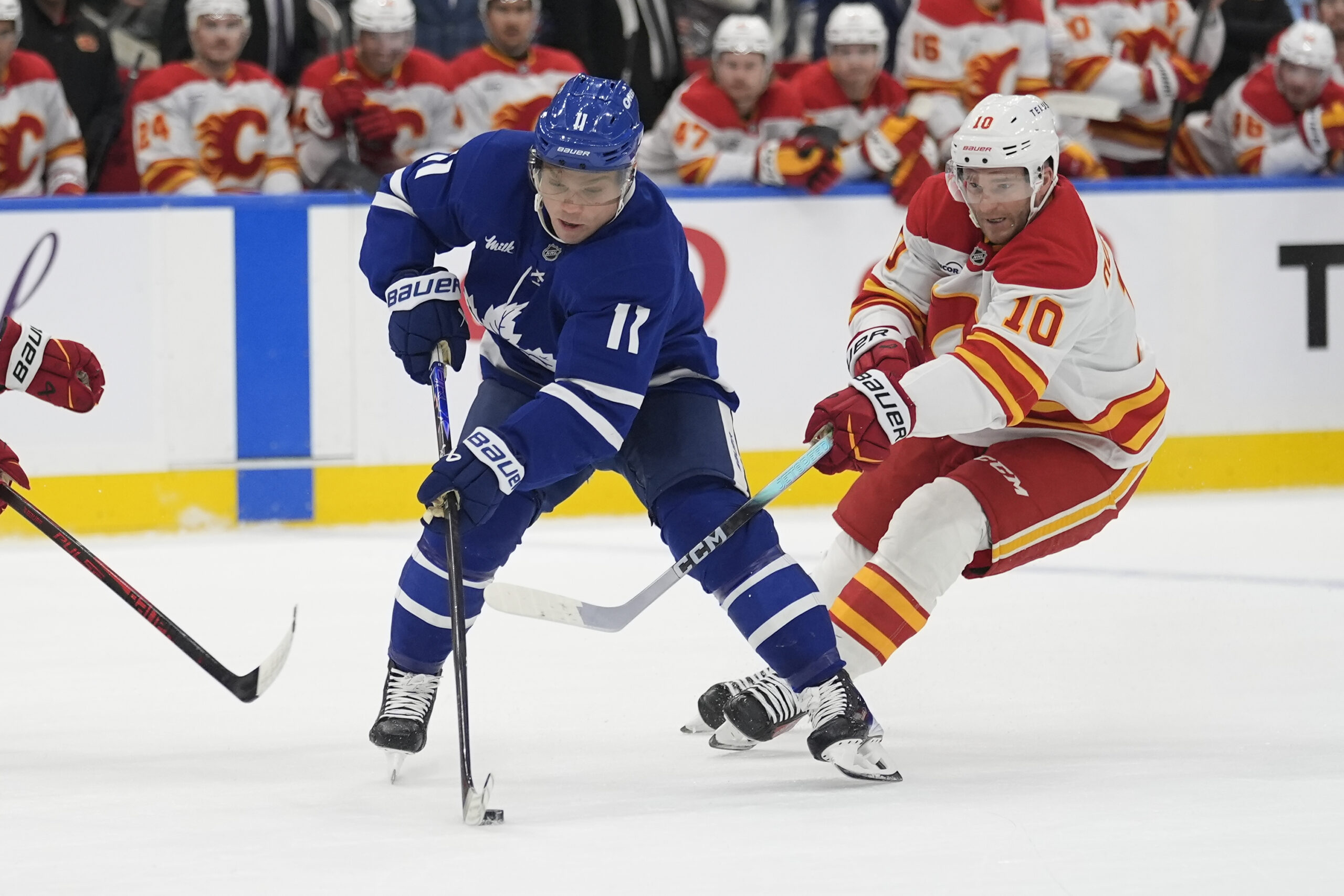 Oct 28, 2025; Toronto, Ontario, CAN; Toronto Maple Leafs forward Max Domi (11) controls the puck against Calgary Flames forward Jonathan Huberdeau (10) during the first period at Scotiabank Arena. Mandatory Credit: John E. Sokolowski-Imagn Images