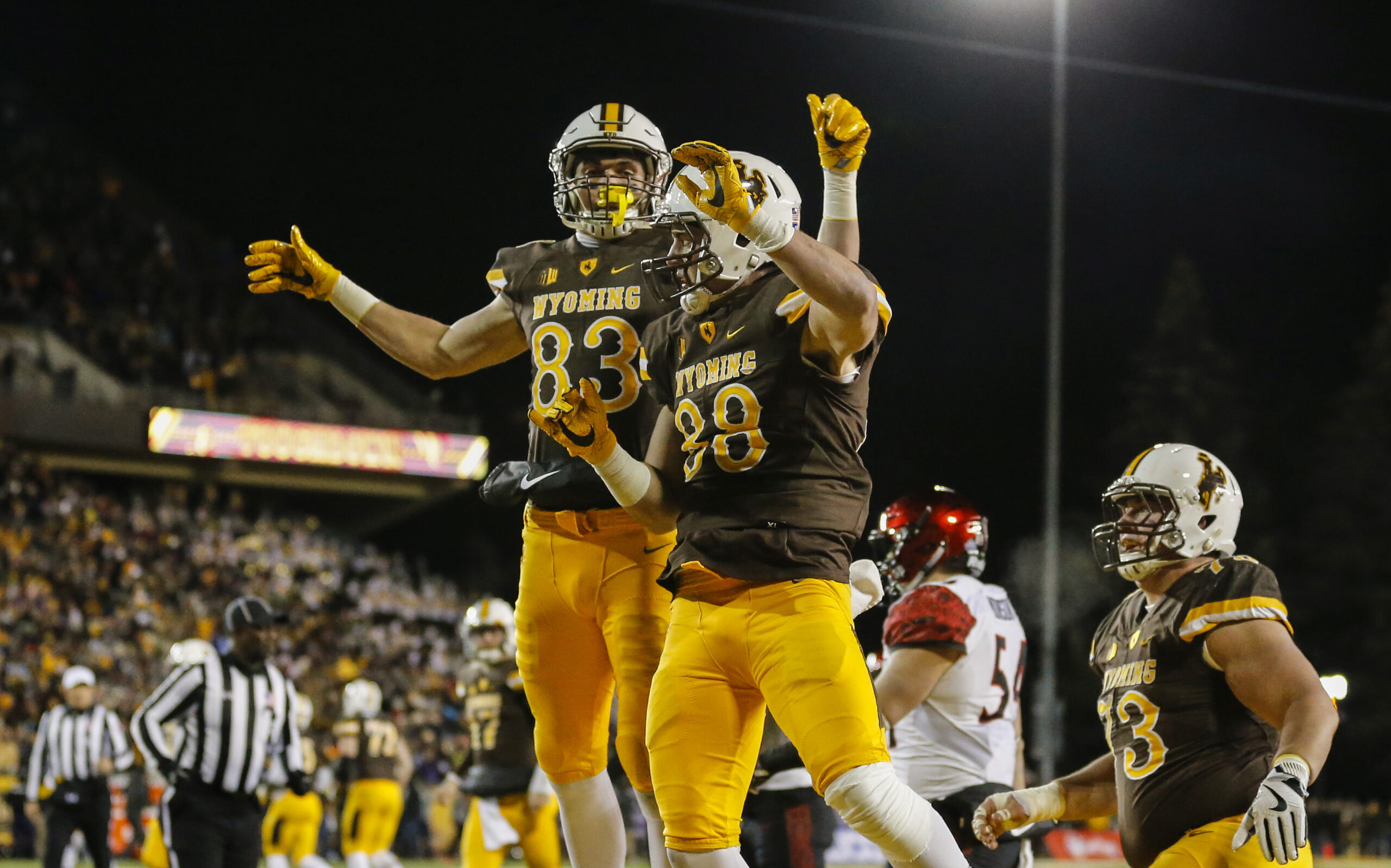 Dec 3, 2016; Laramie, WY, USA; Wyoming Cowboys tight end Jacob Hollister (88) and Jake Maulhardt (83) celebrate a touchdown against San Diego State Aztecs safety Malik Smith (12) during the first quarter at the Mountain West Championship college football game at War Memorial Stadium. Mandatory Credit: Troy Babbitt-Imagn Images