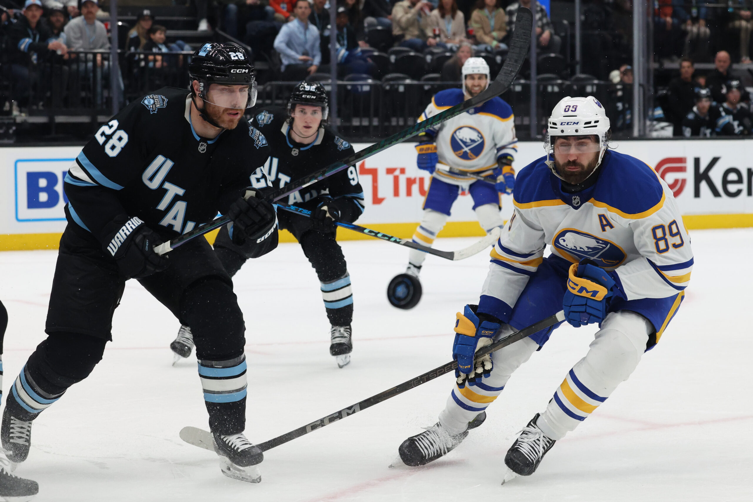 Mar 20, 2025; Salt Lake City, Utah, USA; Utah Hockey Club defenseman Ian Cole (28) and Buffalo Sabres right wing Alex Tuch (89) watch the puck during the third period at Delta Center. Mandatory Credit: Rob Gray-Imagn Images