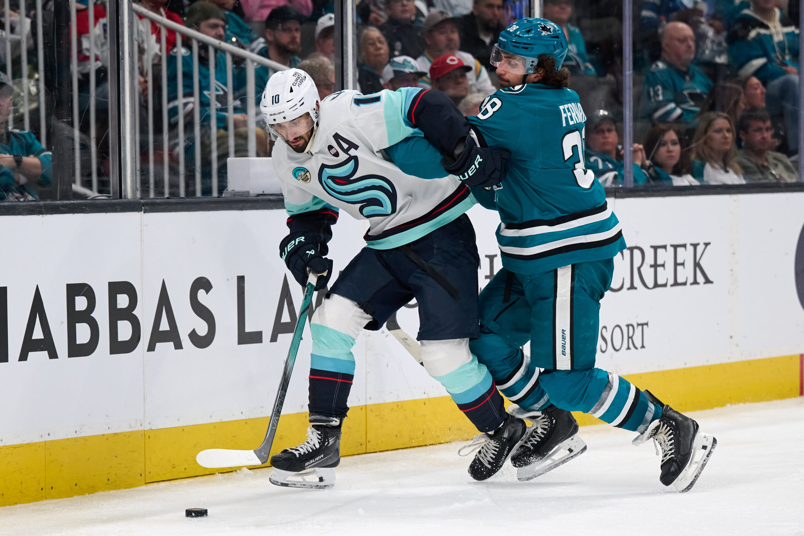 Apr 5, 2025; San Jose, California, USA; Seattle Kraken center Matty Beniers (10) controls the puck against San Jose Sharks defenseman Mario Ferraro (38) during the third period at SAP Center at San Jose. Mandatory Credit: Robert Edwards-Imagn Images