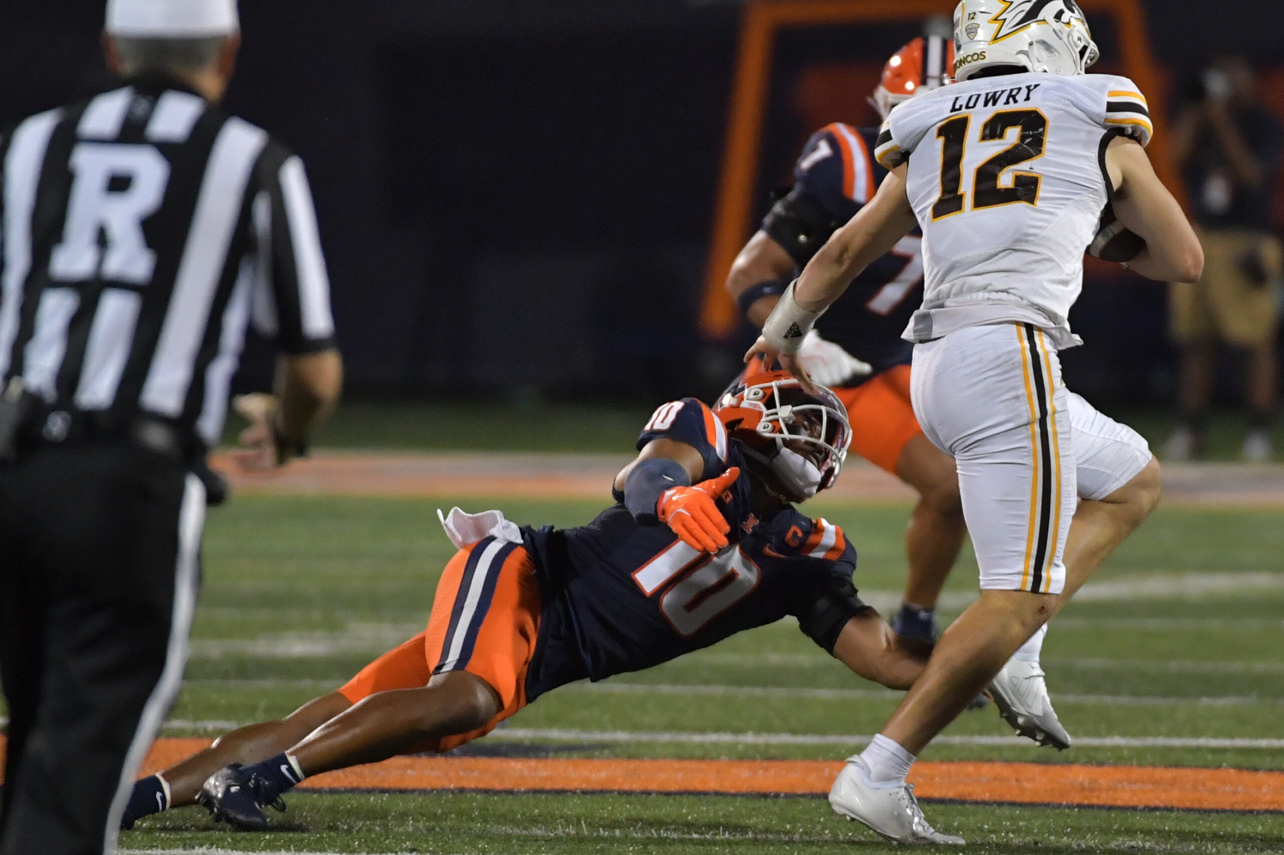Sep 13, 2025; Champaign, Illinois, USA;  Illinois Fighting Illini defensive back Miles Scott (10) tackles Western Michigan Broncos quarterback Broc Lowry (12) during the second half at Memorial Stadium. Mandatory Credit: Ron Johnson-Imagn Images