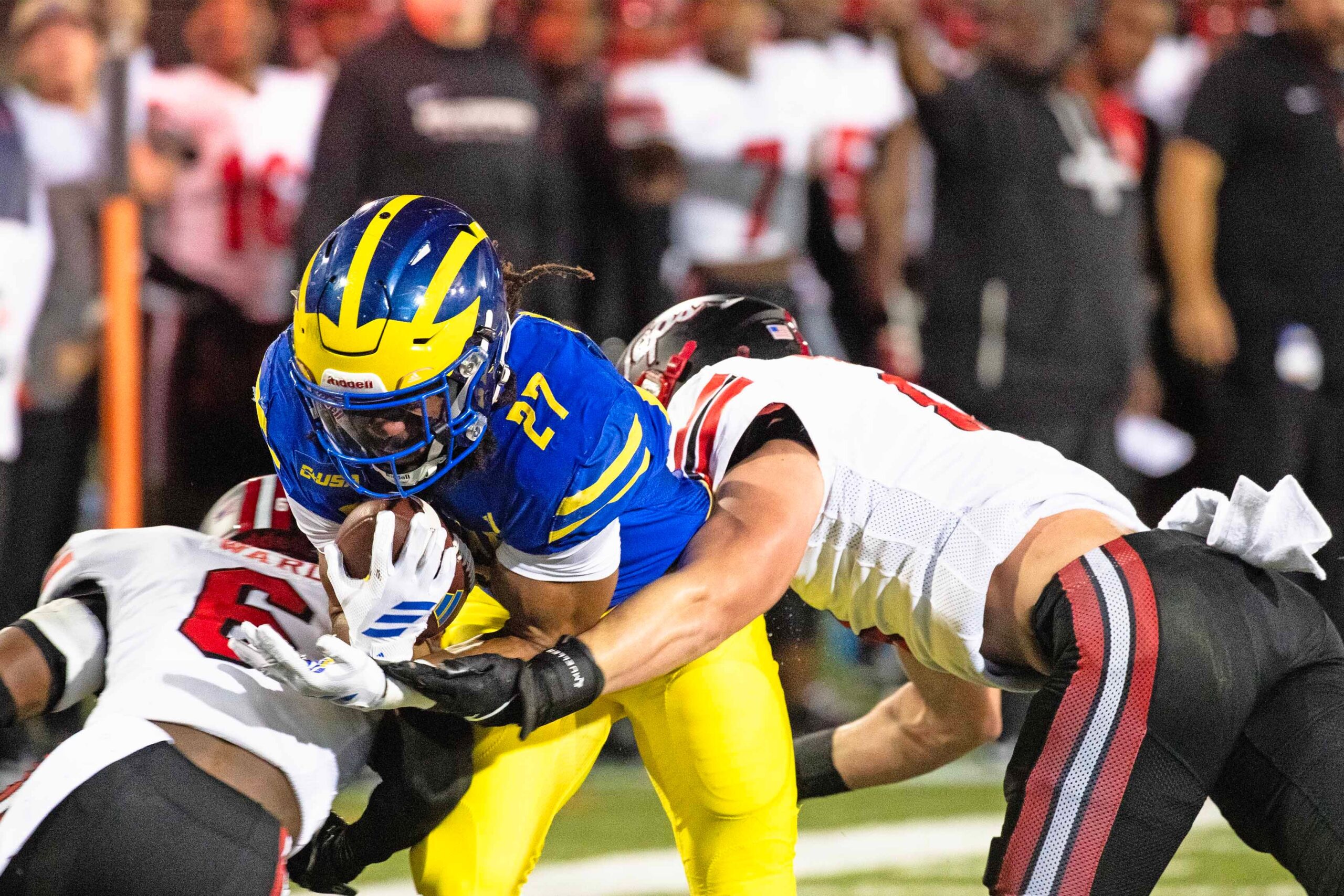 Delaware Blue Hens running back Jo Silver (27) hangs on to the ball as he is flanked by Western Kentucky defensive back Nazir Ward (6) and linebacker Miller Malone (8) for the takedown during Delaware's first home CUSA football game, which was nationally televised, at Delaware Stadium in Newark on Oct. 3, 2025. Western Kentucky won 27-24.