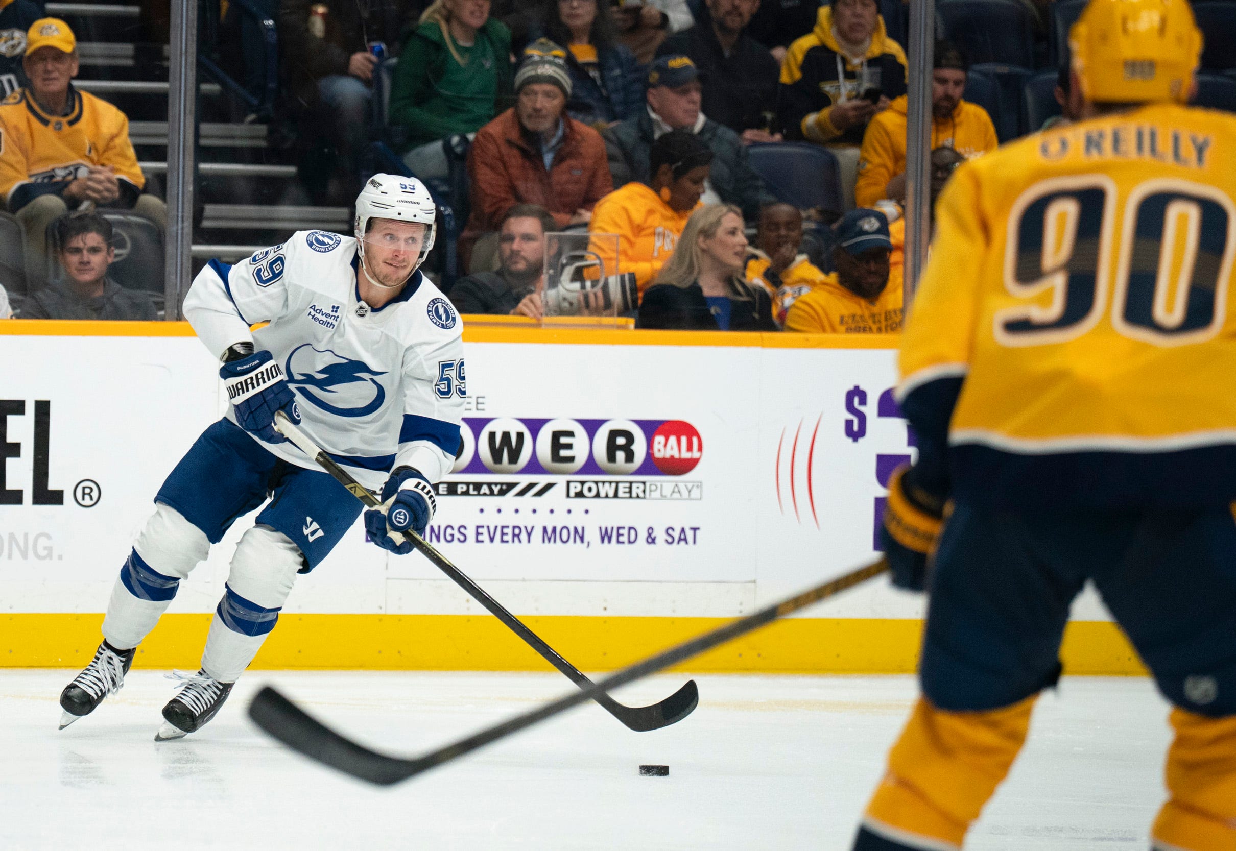 Tampa Bay center Jake Guentzel (59) handles the puck against Nashville center Ryan O'Reilly (90) during their game at Bridgestone Arena in Nashville, Tenn., Tuesday, Oct. 28, 2025.