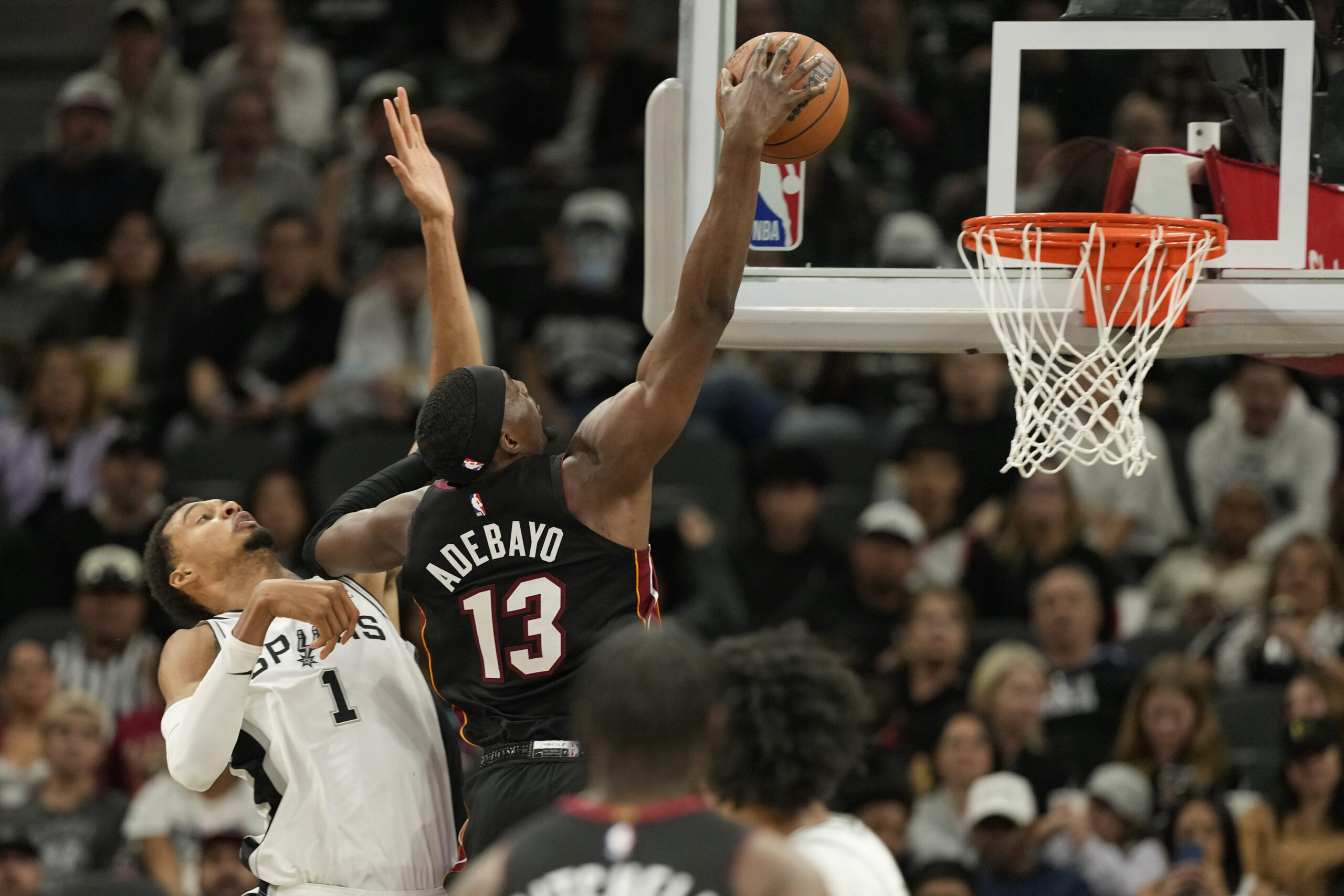 Oct 30, 2025; San Antonio, Texas, USA; Miami Heat forward Bam Adebayo (13) dunks ahead of San Antonio Spurs forward Victor Wembanyama (1) during the first at Frost Bank Center. Mandatory Credit: Scott Wachter-Imagn Images