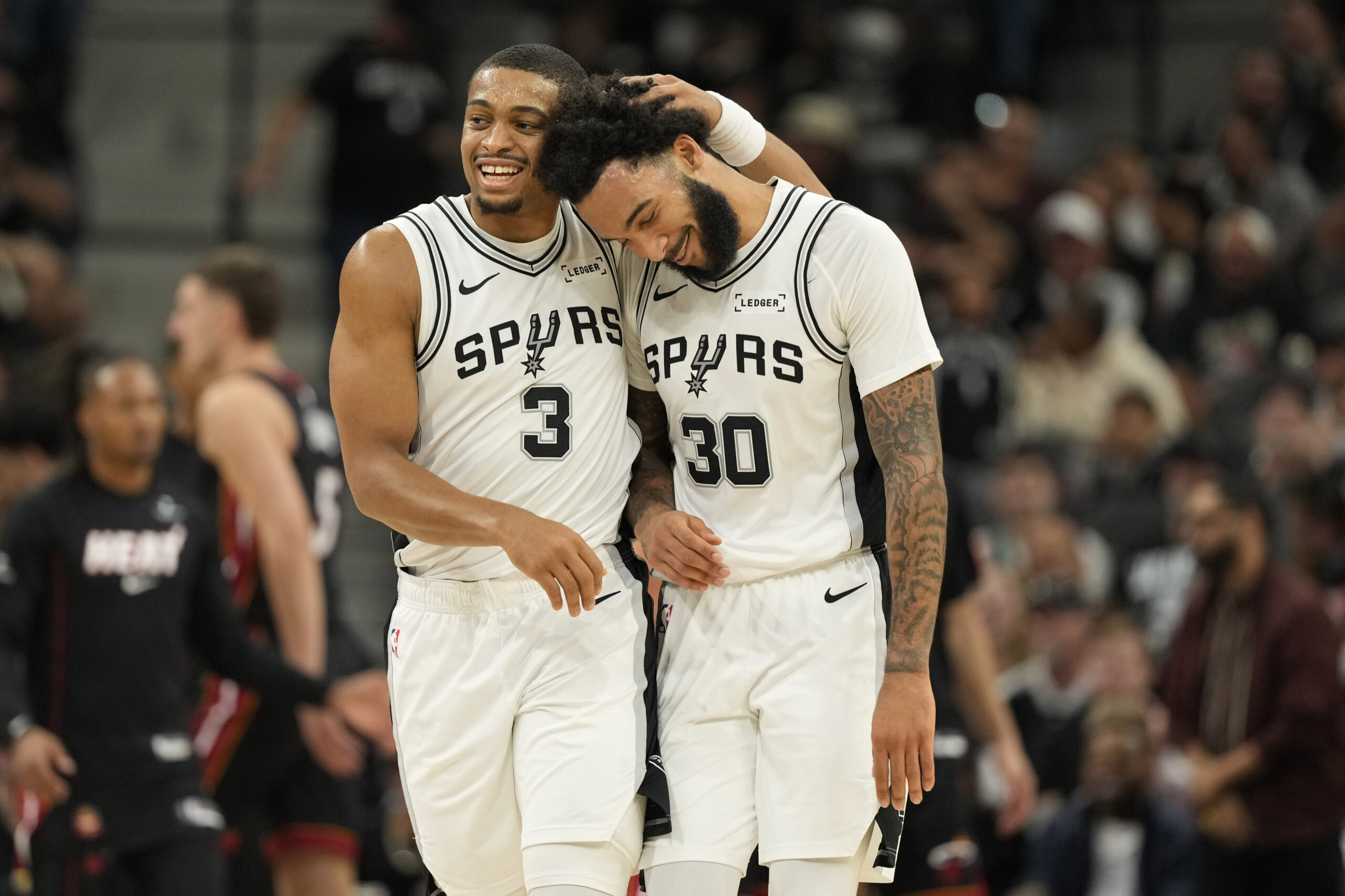 Oct 30, 2025; San Antonio, Texas, USA; San Antonio Spurs forward Keldon Johnson (3) and forward Julian Champagnie (30) react after the first quarter against the Miami Heat at Frost Bank Center. Mandatory Credit: Scott Wachter-Imagn Images