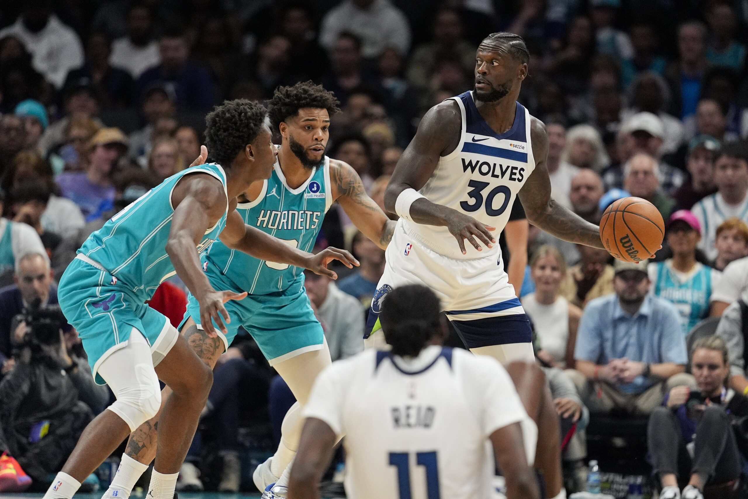 Nov 1, 2025; Charlotte, North Carolina, USA; Minnesota Timberwolves forward Julius Randle (30) looks to pass against Charlotte Hornets forward Miles Bridges (0) and forward Moussa Diabate (14) during the second quarter at Spectrum Center. Mandatory Credit: Jim Dedmon-Imagn Images