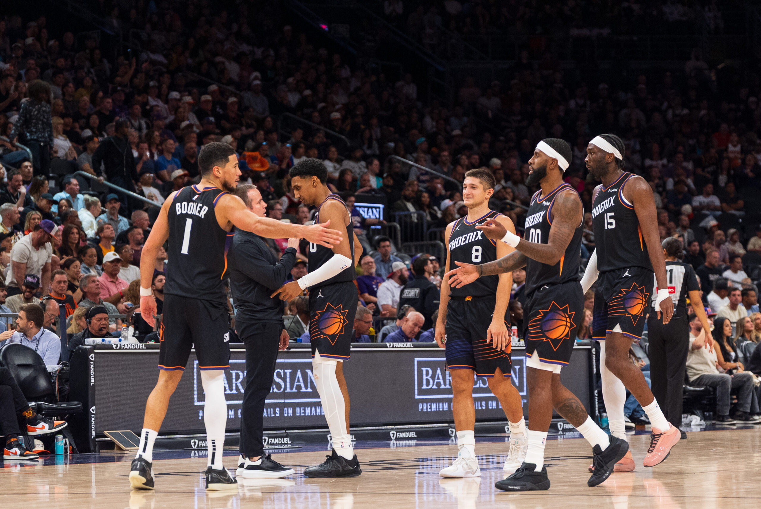 Nov 2, 2025; Phoenix, Arizona, USA; Phoenix Suns guard Devin Booker (1), forward Ryan Dunn (0), Coach Jordan Ott, guard Grayson Allen (8), forward Royce O'Neale (00) and center Mark Williams (15) celebrate during a time-out in the second half against the San Antonio Spurs at Mortgage Matchup Center. Mandatory Credit: Allan Henry-Imagn Images