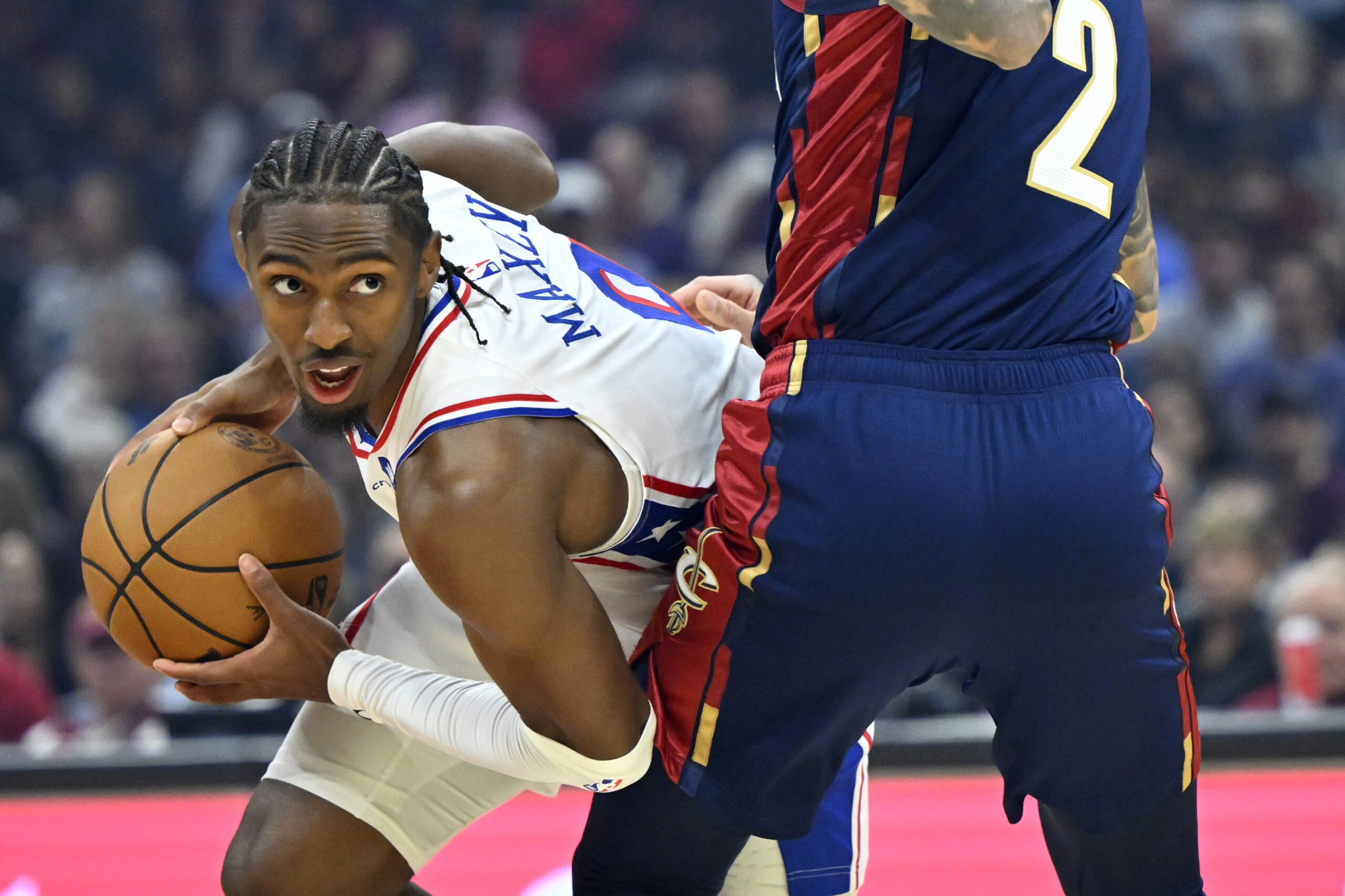 Nov 5, 2025; Cleveland, Ohio, USA; Philadelphia 76ers guard Tyrese Maxey (0) looks to pass beside Cleveland Cavaliers guard Lonzo Ball (2) in the first quarter at Rocket Arena. Mandatory Credit: David Richard-Imagn Images